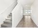 Bright hallway featuring tile flooring, white walls, and a carpeted staircase leading to the upper level at 1844 Brekey Way, Zephyrhills, FL 33541