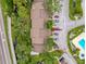 Aerial view of the home's roof and nearby community pool, surrounded by lush greenery and parking spaces at 1200 Tarpon Woods Blvd # L4, Palm Harbor, FL 34685