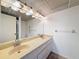 Bathroom with double sink vanity, large mirror and vanity lighting at 1200 Tarpon Woods Blvd # L4, Palm Harbor, FL 34685