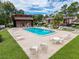 Exterior view of community pool with lounge chairs, dining tables, and a jacuzzi at 1200 Tarpon Woods Blvd # L4, Palm Harbor, FL 34685