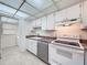 Well-lit kitchen with white cabinets and appliances, adjacent to a laundry area at 1200 Tarpon Woods Blvd # L4, Palm Harbor, FL 34685