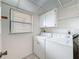 Bright laundry room features a washer, dryer, overhead cabinets, and a window for natural light at 1200 Tarpon Woods Blvd # L4, Palm Harbor, FL 34685