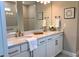 Elegant bathroom with dual sinks, quartz countertops, white cabinetry, and tiled shower with modern fixtures at 2729 Gabel Oak Dr, North Port, FL 34289