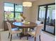 Elegant dining room features a round table, stylish chairs, a modern light fixture, and a view to the outside deck at 2729 Gabel Oak Dr, North Port, FL 34289