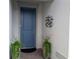 Stylish blue front door with modern hardware, flanked by lush potted plants creating an inviting entrance at 2729 Gabel Oak Dr, North Port, FL 34289