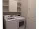 Modern laundry room with a new washer, dryer, white cabinets, and shelving for storage at 2729 Gabel Oak Dr, North Port, FL 34289
