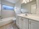 Clean bathroom featuring a tub with shower, white vanity and a large mirror at 5629 Nutmeg Ave, Sarasota, FL 34231