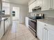 Well-lit kitchen featuring white cabinetry, granite countertops, and stainless steel appliances at 5629 Nutmeg Ave, Sarasota, FL 34231