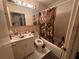 A bathroom featuring a vanity with sink and a shower-tub combination with a decorative shower curtain at 1009 S Clark Ave, Tampa, FL 33629
