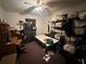 A bedroom interior with a ceiling fan, bed frame, shelves, and desk with a computer at 1009 S Clark Ave, Tampa, FL 33629