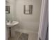 Powder room featuring a pedestal sink, decorative wall art and ceramic flooring at 13707 Newbridge St, Spring Hill, FL 34609