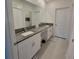 Bathroom features double sinks, granite countertop, and a large mirror, providing a stylish and functional space at 13707 Newbridge St, Spring Hill, FL 34609