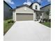 Exterior of a well-maintained two-story home with a wide driveway, landscaped yard and gray exterior at 13707 Newbridge St, Spring Hill, FL 34609