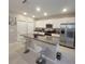 Bright kitchen featuring granite counters, stainless appliances, and a convenient center island with seating at 13707 Newbridge St, Spring Hill, FL 34609