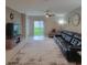 Inviting living room featuring tile floors, a ceiling fan, a large rug and sliding glass doors to backyard at 13707 Newbridge St, Spring Hill, FL 34609
