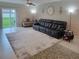 Spacious living room features a large rug, comfortable seating, tile floors and natural light at 13707 Newbridge St, Spring Hill, FL 34609