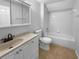 Bathroom features a vanity with storage, a toilet, and a shower-tub combo with tile surround at 16006 Stags Leap Dr, Lutz, FL 33559
