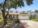 Charming home with a two-car garage, well-maintained landscaping, and a welcoming front porch at 16006 Stags Leap Dr, Lutz, FL 33559