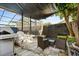 A backyard with covered seating and an outdoor kitchen, next to a screened-in lanai with a swimming pool at 1716 Westerly Dr, Brandon, FL 33511