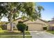 Charming one-story home with a well-maintained lawn, mature trees, and an attached two-car garage at 1716 Westerly Dr, Brandon, FL 33511