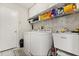 Functional laundry room with washer, dryer, sink, storage shelves, and tiled floors at 1716 Westerly Dr, Brandon, FL 33511