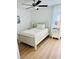 Bright bedroom with a ceiling fan, light wood floors, and a large window at 9937 Aqua Miles Path, Wesley Chapel, FL 33545