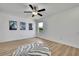 Bright, minimalist bedroom with ceiling fan, window, and zebra print rug, offering a calming atmosphere at 9937 Aqua Miles Path, Wesley Chapel, FL 33545