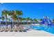 Stunning community pool area featuring a thrilling water slide, lounge chairs, and lush tropical landscaping and blue skies at 9937 Aqua Miles Path, Wesley Chapel, FL 33545