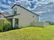 Exterior view of home with manicured lawn, a fence, and blue skies with fluffy clouds at 9937 Aqua Miles Path, Wesley Chapel, FL 33545