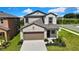 Two-story home with a two-car garage, manicured landscaping, and neutral color scheme at 9937 Aqua Miles Path, Wesley Chapel, FL 33545