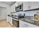 Sleek kitchen features stainless steel appliances, granite countertop, and bright white cabinetry at 9937 Aqua Miles Path, Wesley Chapel, FL 33545