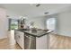 Bright kitchen island featuring granite countertops, stainless steel appliances, and modern chandelier at 9937 Aqua Miles Path, Wesley Chapel, FL 33545