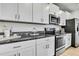 Bright kitchen features stainless steel appliances, granite countertops, and modern white cabinets at 9937 Aqua Miles Path, Wesley Chapel, FL 33545