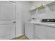 Bright laundry room featuring a washer, dryer, overhead shelf with towels, and a closed closet at 9937 Aqua Miles Path, Wesley Chapel, FL 33545