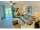 Inviting living room featuring stylish furniture, neutral tones, and sliding glass doors to the backyard at 9937 Aqua Miles Path, Wesley Chapel, FL 33545