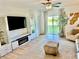 Bright living room with a ceiling fan, sleek furniture, and sliding glass doors to the backyard at 9937 Aqua Miles Path, Wesley Chapel, FL 33545