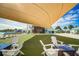 Inviting outdoor lounge area with comfortable seating, shade, and a view of the community amenities and outdoor television at 9937 Aqua Miles Path, Wesley Chapel, FL 33545