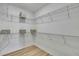 Spacious walk-in closet with wire shelving and wood-look flooring offers abundant storage space for organization at 9937 Aqua Miles Path, Wesley Chapel, FL 33545