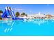 Beautiful shot of the waterpark and community pool with water slide, white buildings, and blue skies at 9937 Aqua Miles Path, Wesley Chapel, FL 33545