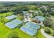 Aerial view of the community amenities, including tennis courts, parking, and a clubhouse, amid lush greenery at 17032 Winners Cir, Odessa, FL 33556