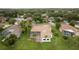 Bird's eye view of a well-maintained home with tile roof, screened pool, lush lawn, and waterfront access at 17032 Winners Cir, Odessa, FL 33556