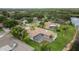 High angle drone shot of property with lake views, outdoor pool, mature landscaping, and tile roof at 17032 Winners Cir, Odessa, FL 33556