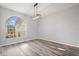 Dining room with a modern chandelier, a large arched window, and laminate floors at 17032 Winners Cir, Odessa, FL 33556