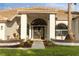 The covered entry way welcomes you to the home's gorgeous arched front doors and landscaping at 17032 Winners Cir, Odessa, FL 33556