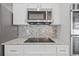 Close up view of a kitchen backsplash, cooktop, and granite countertop at 17032 Winners Cir, Odessa, FL 33556