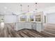 Open kitchen with granite island, stainless appliances, and hardwood floors in adjacent living space at 17032 Winners Cir, Odessa, FL 33556