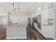 Well-lit kitchen features wood flooring, stainless steel appliances, granite countertops, and white cabinetry at 17032 Winners Cir, Odessa, FL 33556