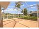Enclosed lanai offering views of the backyard, lake, and lush greenery at 17032 Winners Cir, Odessa, FL 33556