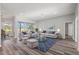 Spacious living room area with wood floors, stylish furniture, and sliding glass doors to outdoor pool at 17032 Winners Cir, Odessa, FL 33556