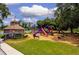 Community playground with slides and climbing structures surrounded by well-maintained landscaping and seating at 17032 Winners Cir, Odessa, FL 33556
